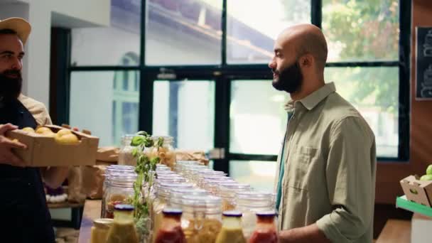 Vásárló élvezi a gazdag citrom illatát a helyi bio szupermarket, élelmiszerbolt kereskedő ad gyümölcsöt az ügyfélnek. Fiatal ügyfél szagú termékek, reklám vegán fenntartható életmód. - Felvétel, videó