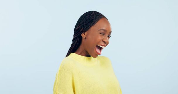 Wink, flirty and portrait of a black woman on a studio background for love, conversation or a smile. Happy, mockup space and an African person with facial expression for a secret or confident. - Zdjęcie, obraz