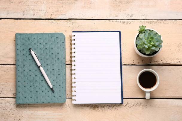 Notebooky s perem a šálkem chutné kávy na bílém dřevěném pozadí - Fotografie, Obrázek