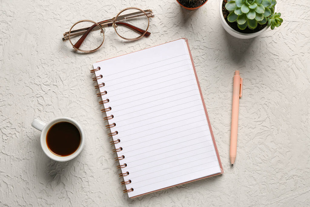Notebook s brýlemi a šálek chutné kávy na bílém pozadí - Fotografie, Obrázek