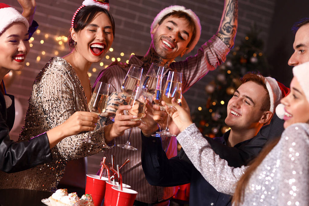 Группа друзей пьет шампанское на новогодней вечеринке - Фото, изображение