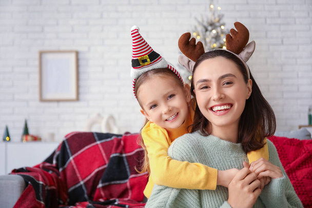 Happy mother and her little daughter at home on Christmas eve - Photo, Image