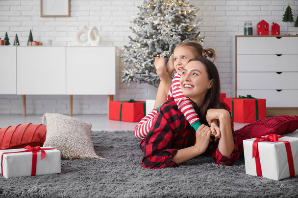 Onnellinen äiti ja hänen pieni tyttärensä kotona jouluaattona - Valokuva, kuva
