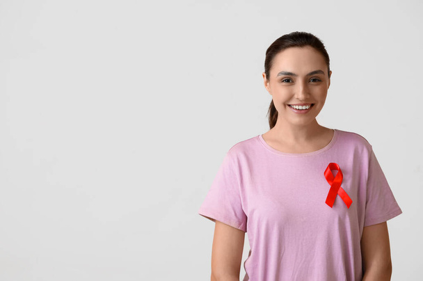 白い背景に赤いリボンを持つ若い女性. AID認知コンセプト - 写真・画像