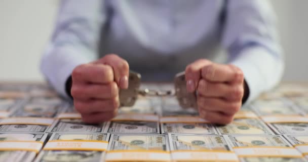 Frau sitzt in Handschellen und jede Menge Dollarscheine liegen auf dem Tisch. Bestechung, Korruption und Verhaftung - Filmmaterial, Video