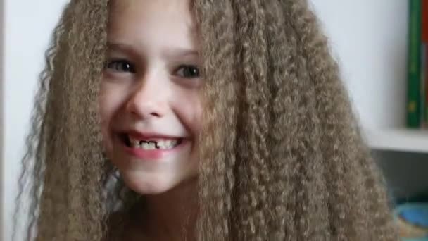 Aranyos kislány mosolyog és megmutatja az elesett tejfogait. Fognövekedés. Közelkép. Egy 6 éves rebec portréja. - Felvétel, videó