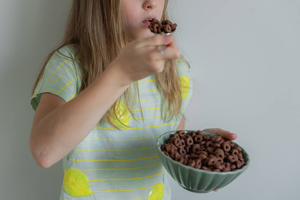 Little Blond Girl Eating Chocolate Flakes Indoor  - Photo, Image