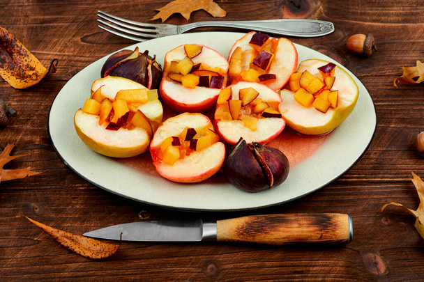 Manzanas dulces al horno e higos. Postre vegano casero sobre un fondo de madera rústica. - Foto, imagen