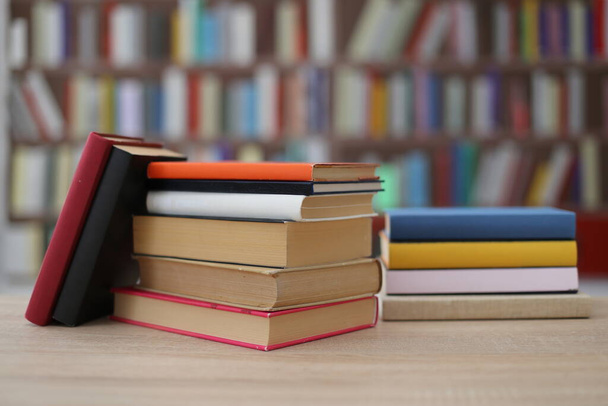 купа різнокольорових книг на столі в бібліотеці - Фото, зображення