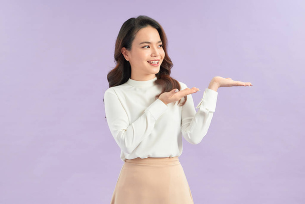 Beautiful young Asian woman show palm hand on color background - Photo, Image
