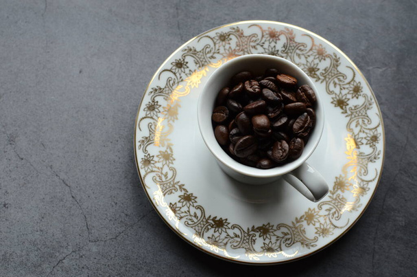 Tasse Kaffee mit Bohnen und Kaffeebohnen auf dem Tisch. - Foto, Bild