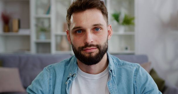 Portrait face of smiling man with blue eyes and beard sitting inside office, posing and looking straight at the camera objective having positive emotions - Foto, imagen