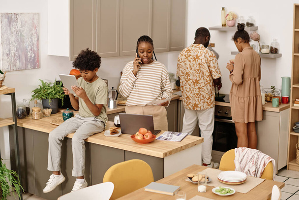 Czarna rodzina spędza czas w domu gotowania, pracy i nauki - Zdjęcie, obraz