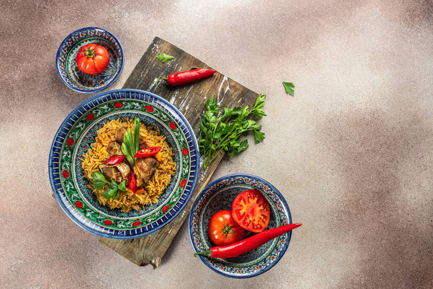 leckere asiatische Pilaf in Teller mit orientalischem Ornament, usbekische orientalische Küche auf hellem Hintergrund von oben. Platz für Text. - Foto, Bild