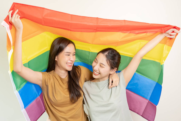 Ομάδα ΛΟΑΤ. Όμορφα λεσβιακά ζευγάρια χαμογελούν έντονα καλύπτουν σημαίες ουράνιο τόξο. Ασιατικό νεαρό ζευγάρι αγκαλιάζει ο ένας τον άλλον ευτυχισμένα, ερωτευμένος, αμφιφυλοφιλία, ομοφυλοφιλία, ελευθερία, έκφραση, ευτυχισμένη ζωή - Φωτογραφία, εικόνα