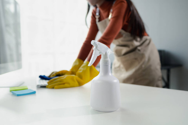Sprzątacze wycierający sprzęt biurowy, wyczyścić klawiaturę ręcznikiem i środkiem dezynfekującym, nosić gumowe rękawice podczas pracy z chemikaliami czyszczącymi, pomysł na czyszczenie. - Zdjęcie, obraz