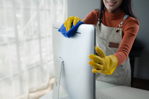Woźny sprzątający biuro, Czyścić monitor szmatą, nosić rękawiczki i wycierać ręcznikiem, Nosić gumowe rękawiczki podczas pracy z chemikaliami czyszczącymi, Pomysł czyszczenia. - Zdjęcie, obraz