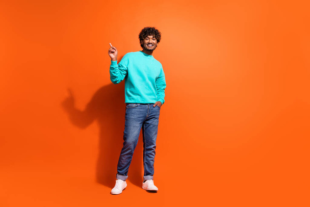 Full length portrait of nice handsome man indicate finger empty space novelty isolated on orange color background. - Foto, afbeelding
