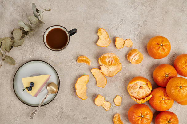 спелые мандарины и традиционный горячий шоколадный напиток и рождественский пудинг на серой текстурной поверхности - Фото, изображение