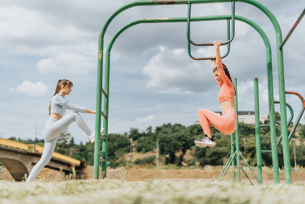 Ryhmä itsevarmoja, sopivia nuoria naisia harjoittelemassa ulkona puistossa, inspiroimassa muita johtamaan terveellistä ja aktiivista elämäntapaa.. - Valokuva, kuva