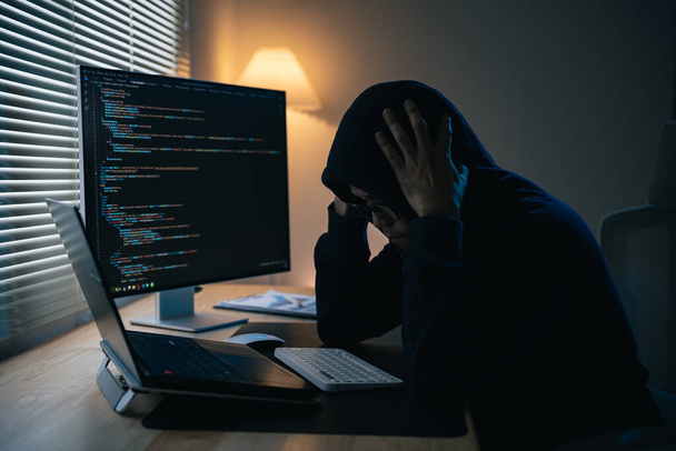 Hacker άνθρωπος φορώντας γυαλιά και κουκούλα κατάθλιψη ή σοβαρό λάθος για hack σύστημα ασφαλείας του δικτύου. Επικίνδυνο Hacker Παραβιάζει κυβερνητικούς διακομιστές δεδομένων και μολύνει το σύστημά τους με έναν ιό. - Φωτογραφία, εικόνα
