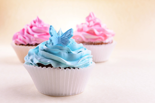 Delicious cupcakes on beige background - Foto, imagen