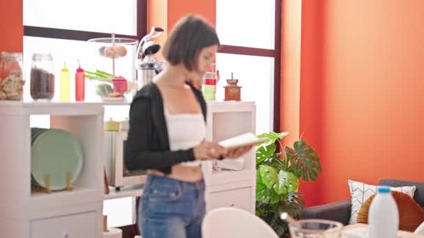 Όμορφο ζευγάρι ανάγνωση βιβλίο συνταγών φιλιά στην τραπεζαρία - Πλάνα, βίντεο