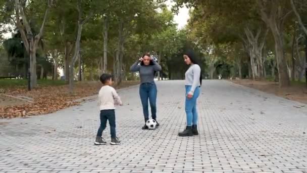 Ένα ζευγάρι Λατίνων λεσβιών παίζει ποδόσφαιρο με το γιο τους σε ένα πάρκο. Οικογένεια ΛΟΑΤ. - Πλάνα, βίντεο