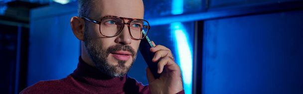 zamyšlený specialista na datové centrum s vousy a brýlemi v roláku telefonicky hovořící při práci, banner - Fotografie, Obrázek