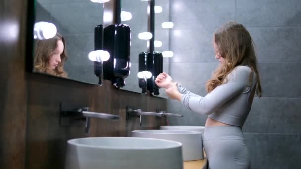Közelkép egy félvér nőről, aki kezet mos a fürdőszobában, lassított felvétel. Öngondoskodás, higiénia, életmód és családi élet. száraz kéz a szárítóban készlet videó tinédzser - Felvétel, videó