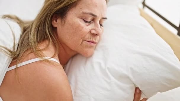 Middelbare leeftijd Spaanse vrouw liggend op bed slapen in de slaapkamer - Video