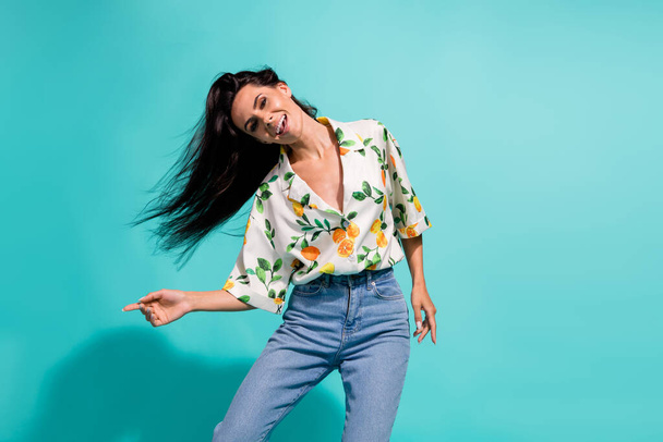Portrait of cheerful adorable woman dressed flower print blouse fluttering hair enjoy music isolated on turquoise color background. - Фото, зображення