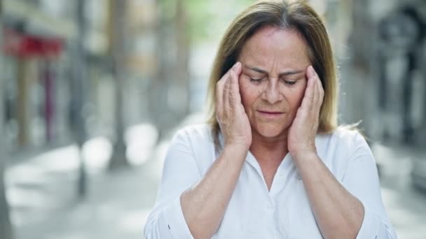 Μεσήλικας Ισπανίδα γυναίκα που υποφέρει από πονοκέφαλο στο δρόμο - Πλάνα, βίντεο