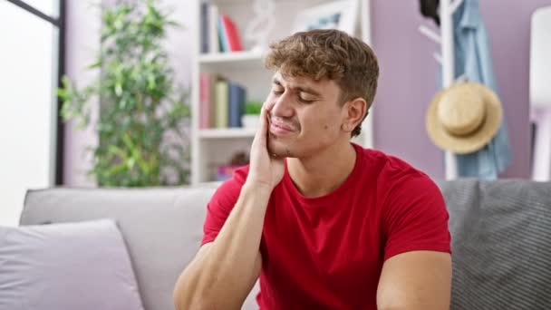 Young hispanic man stressed sitting on sofa at home - Filmmaterial, Video