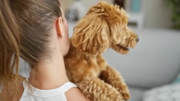 Jeune femme caucasienne avec chien étreignant à l'envers à la maison - Séquence, vidéo