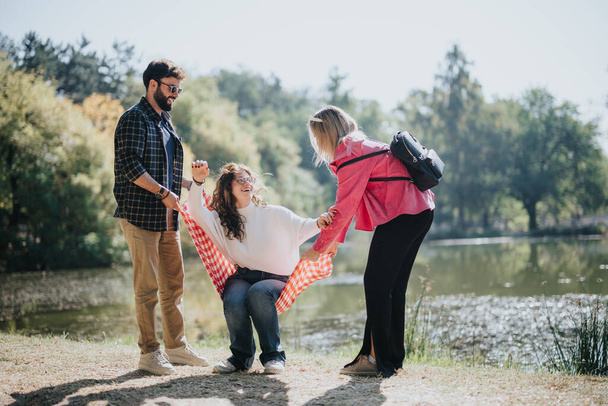 Οι φίλοι απολαμβάνουν ανέμελη συνομιλία κοντά σε μια λίμνη της πόλης. Παιχνιδιάρικη ομάδα από χαρούμενους νέους Καυκάσιους που απολαμβάνουν τη φύση και το πράσινο περιβάλλον, δημιουργώντας θετική ενέργεια. - Φωτογραφία, εικόνα
