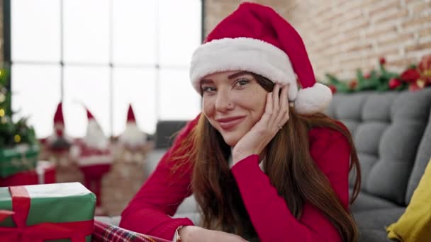 Mladá hispánská žena slaví Vánoce ležící na pohovce doma - Záběry, video
