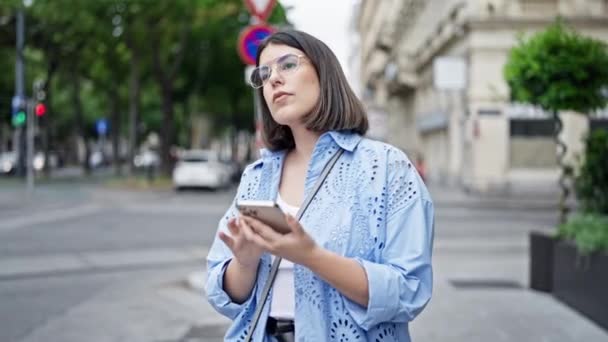Νεαρή όμορφη ισπανόφωνη γυναίκα συναντά ένα φίλο χρησιμοποιώντας smartphone στους δρόμους της Βιέννης - Πλάνα, βίντεο