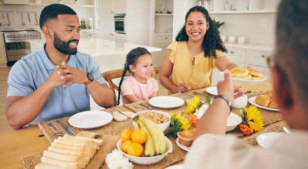 Γονείς, παππούδες και παιδιά στο τραπέζι για πρωινό, δείπνο και γεύμα μαζί για δέσιμο στο σπίτι. Οικογένεια, ευτυχισμένη και μητέρα, πατέρας και παιδιά με φαγητό για φαγητό, κοινωνική συγκέντρωση και ευεξία. - Φωτογραφία, εικόνα