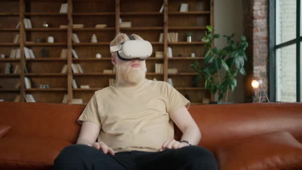 Przystojny, młody hipsterze, noszący słuchawki rzeczywistości wirtualnej dla doświadczenia Augmented Reality. Mężczyzna dotknąć czegoś za pomocą nowoczesnych google 3D VR w pomieszczeniach, grając za pomocą okularów AR w słoneczny dzień czasu 4K - Materiał filmowy, wideo