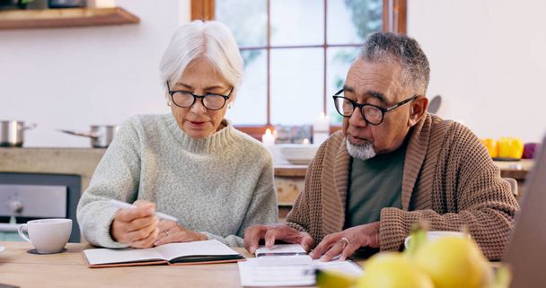 Senior couple, budget and finance notebook with writing and life insurance information for will at table. Discussion, list and paper for process and bills review in print in a retirement home. - 写真・画像