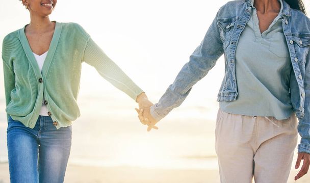 Liefde, strand en lesbisch koppel op handen houden op zonsondergang vakantie avontuur, datum of kwaliteit tijd samen. Lgbt vrouwen, binden en ontspannen op oceaan vakantie met romantiek, trots en gelukkig in de natuur - Foto, afbeelding