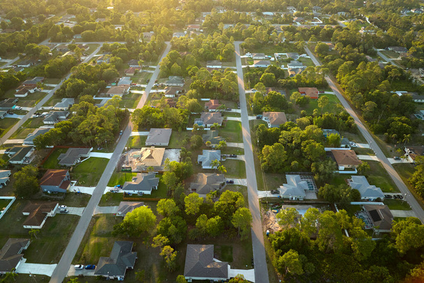 Αεροφωτογραφία του προαστιακού τοπίου με ιδιωτικές κατοικίες μεταξύ πράσινων φοινικόδεντρων στη Φλόριντα ήσυχη κατοικημένη περιοχή. - Φωτογραφία, εικόνα