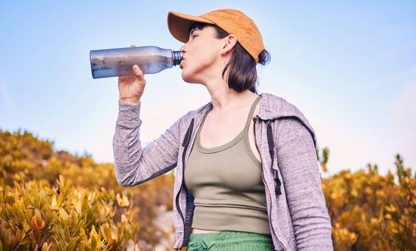 Pensamento, caminhadas e mulheres bebendo água na natureza para o bem-estar, saúde e após o treinamento. Hidratação, ideia e um atleta com uma garrafa para beber depois de correr, exercitar ou cardio na montanha. - Foto, Imagem