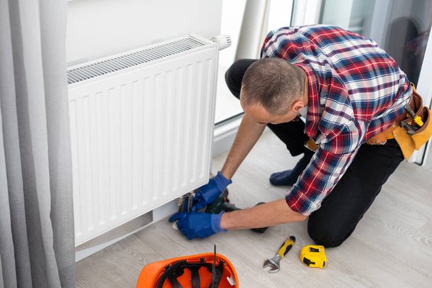 man repairing radiator with wrench. Removing air from the radiator. High quality photo - Photo, Image