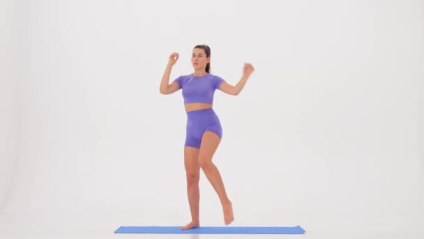  Γυμναστική. Αθλητική γυναίκα που γυμνάζεται σε λευκό φόντο. αργή κίνηση. όνομα άσκησης - καταλήψεις αέρα  - Πλάνα, βίντεο