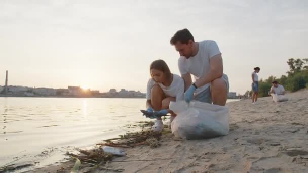 Un groupe d'éco-activistes nettoie les ordures dans la nature. Gros plan d'un jeune qui ramasse des ordures dans un sac en plastique dans la nature. Le concept de vie verte et d'écologie. Images 4k de haute qualité - Séquence, vidéo