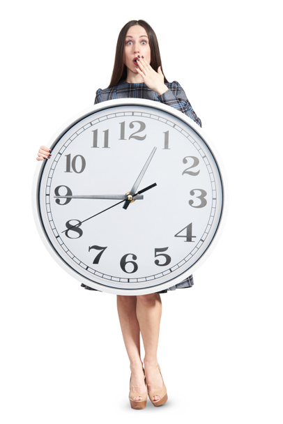 mujer asombrada sosteniendo reloj grande
 - Foto, imagen