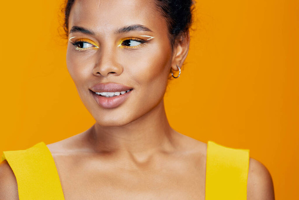 Женская красота улыбка черная студия кожа модель макияж красивый стиль африканского лица желтый косметолог портрет косметическая копия пространство красочные розовые этнические творческие моды - Фото, изображение