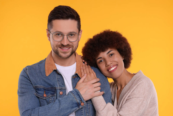International dating. Portrait of happy couple on orange background - Φωτογραφία, εικόνα